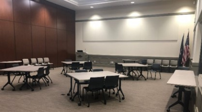 Community Room A set up with tables and projector screen